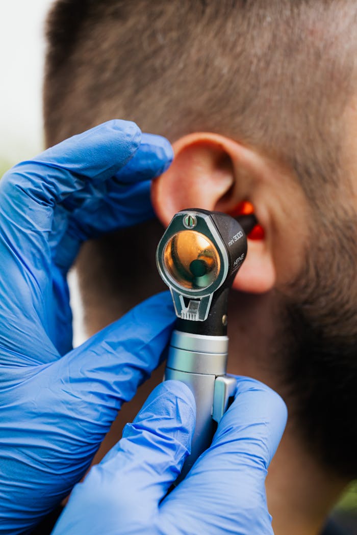 digital Close-up of a doctor using an otoscope to examine a patient's ear.